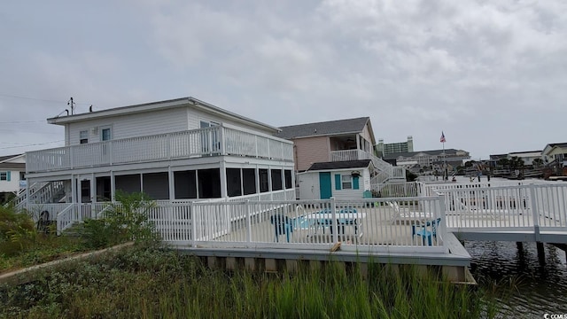 rear view of property featuring a fenced in pool and a sunroom