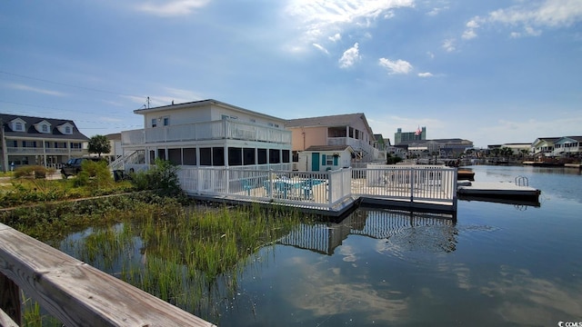 view of dock featuring a swimming pool and a water view