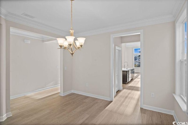 dining room with crown molding, sink, a chandelier, and light hardwood / wood-style floors