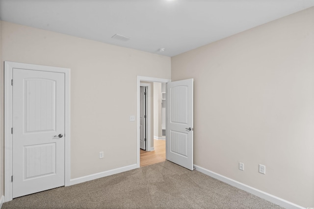 unfurnished bedroom featuring light carpet