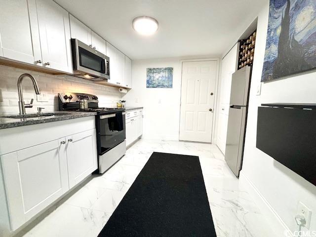 kitchen with white cabinetry, sink, backsplash, and stainless steel appliances