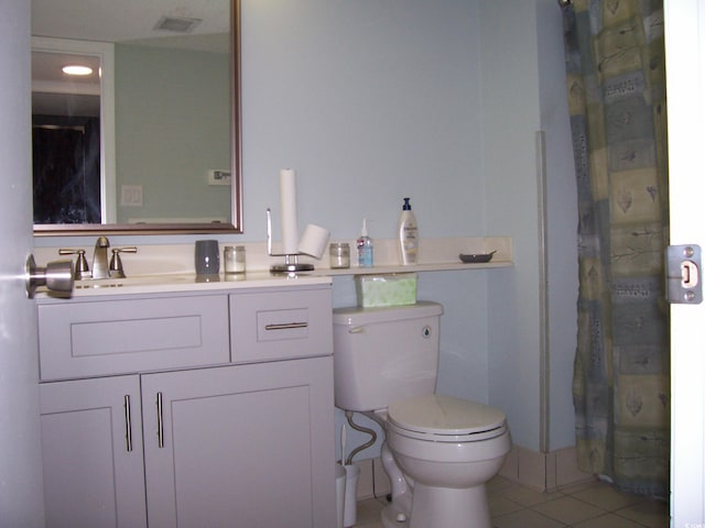 bathroom with tile patterned flooring, a shower with shower curtain, vanity, and toilet