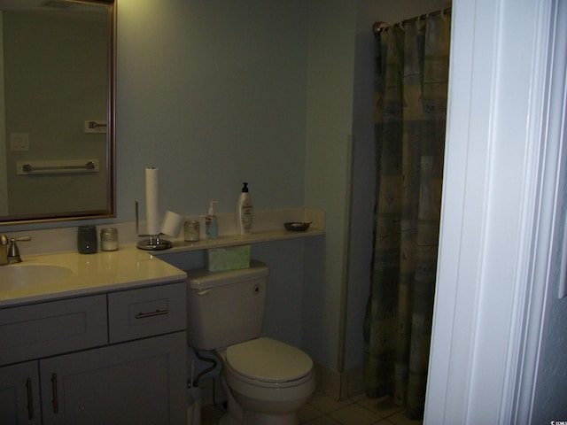 bathroom featuring tile patterned flooring, curtained shower, vanity, and toilet