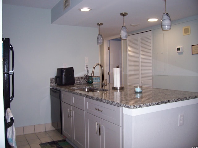 kitchen featuring light tile patterned flooring, dark stone counters, sink, hanging light fixtures, and black appliances