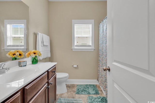 bathroom with vanity, baseboards, and toilet