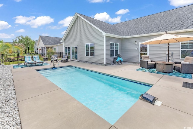 view of swimming pool with an outdoor living space with a fire pit, fence, a fenced in pool, and a patio