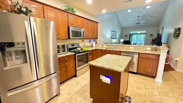 kitchen with ceiling fan, kitchen peninsula, appliances with stainless steel finishes, a center island, and vaulted ceiling