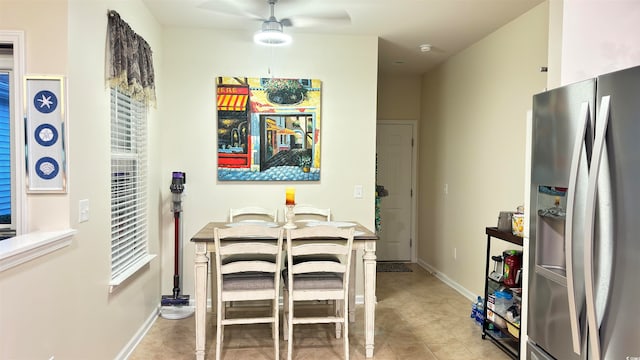 dining space with ceiling fan and light tile patterned flooring