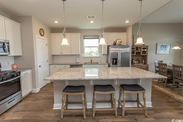 kitchen with white cabinets, appliances with stainless steel finishes, and a kitchen island