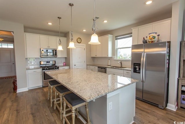 kitchen featuring stainless steel appliances, white cabinetry, and a kitchen island