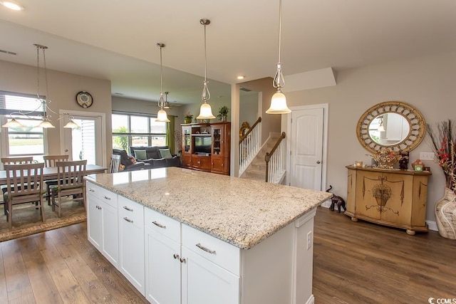 kitchen featuring hanging light fixtures, a kitchen island, dark hardwood / wood-style floors, and white cabinets