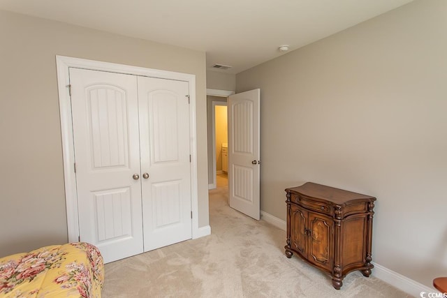 bedroom with light carpet and a closet