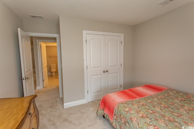 bedroom with light carpet and a closet