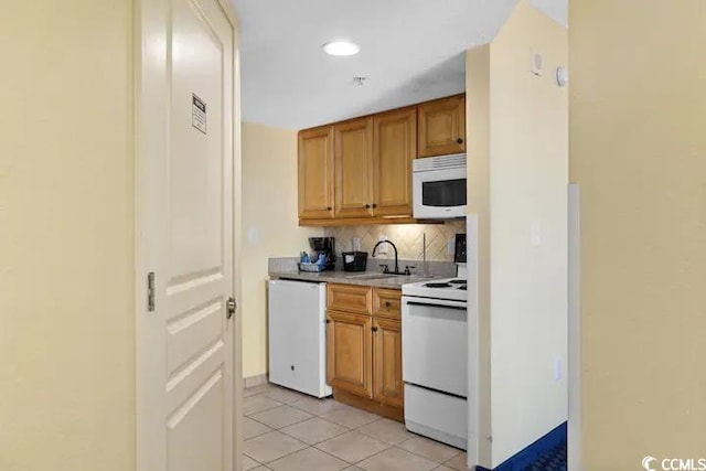 kitchen featuring light tile patterned floors, sink, decorative backsplash, and white appliances