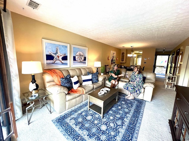 carpeted living area with a notable chandelier, visible vents, and a textured ceiling