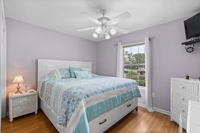 bedroom with ceiling fan and light hardwood / wood-style floors