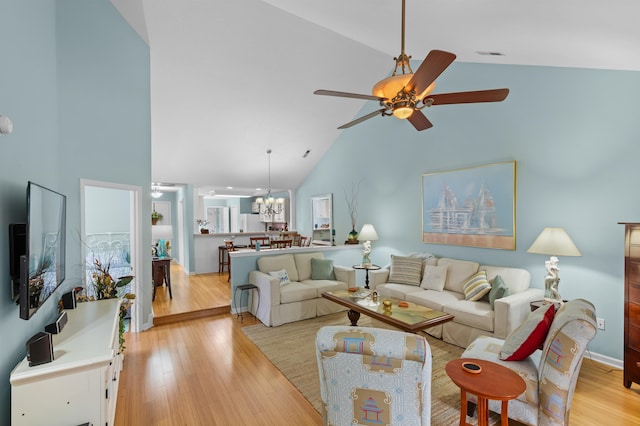 living room featuring light wood-type flooring, high vaulted ceiling, and ceiling fan with notable chandelier