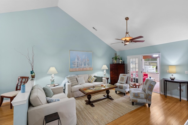 living room with high vaulted ceiling, ceiling fan, and light wood-type flooring