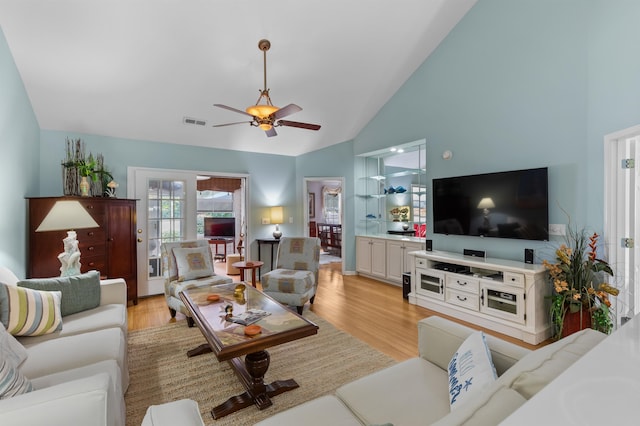 living room featuring light hardwood / wood-style floors, high vaulted ceiling, and ceiling fan