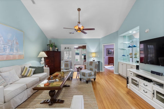 living room with ceiling fan, high vaulted ceiling, and light hardwood / wood-style floors