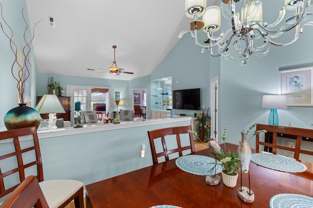 dining area featuring ceiling fan with notable chandelier, lofted ceiling, and hardwood / wood-style floors