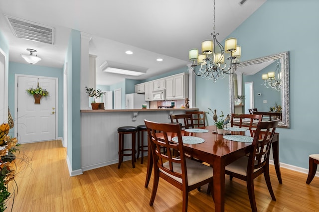 dining area featuring light hardwood / wood-style floors and a chandelier