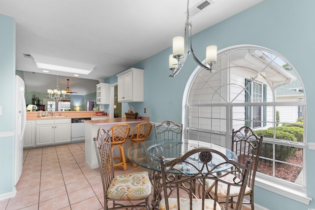 tiled dining room with sink and a notable chandelier