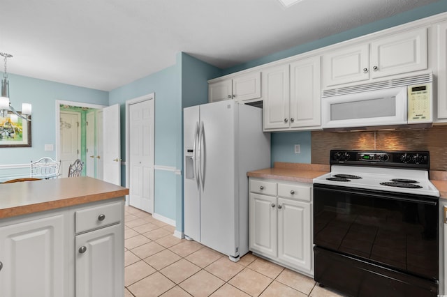 kitchen with light tile patterned floors, white cabinets, white appliances, and decorative light fixtures