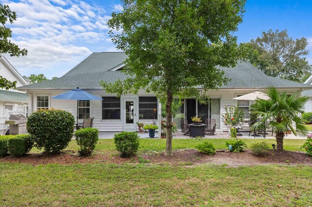 back of property with a patio area and a lawn