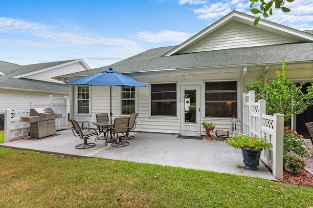 back of house with a lawn and a patio