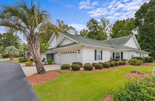 view of front of house with a garage and a front lawn