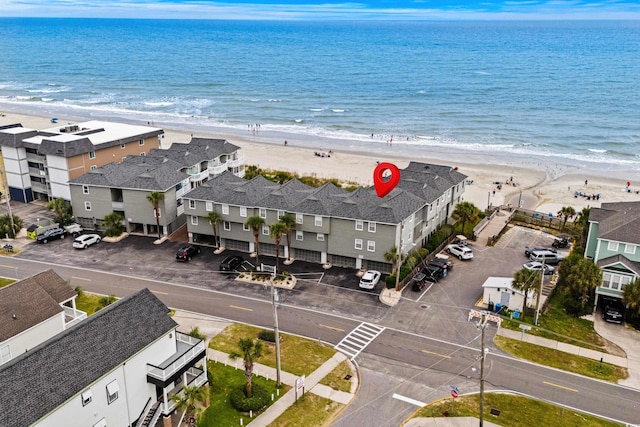 birds eye view of property featuring a water view, a residential view, and a beach view