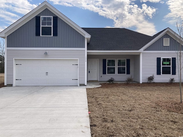 view of front of house with a garage, concrete driveway, and roof with shingles