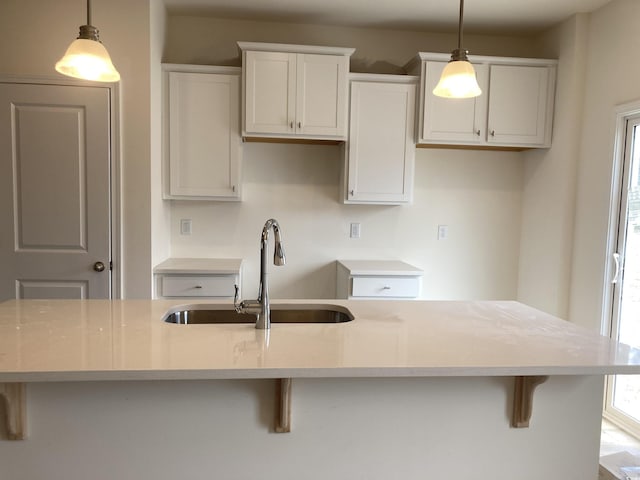 kitchen with a healthy amount of sunlight, white cabinetry, and a sink