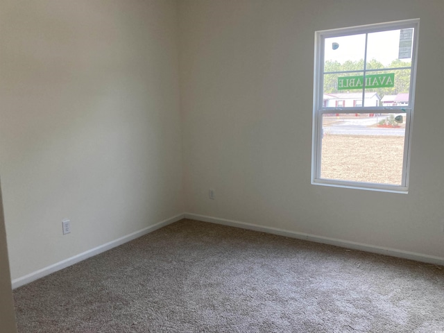 carpeted spare room featuring baseboards