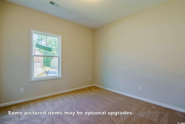 unfurnished room with carpet floors, visible vents, and baseboards