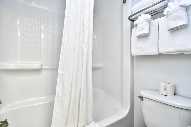 bathroom featuring toilet and shower / bath combination with curtain