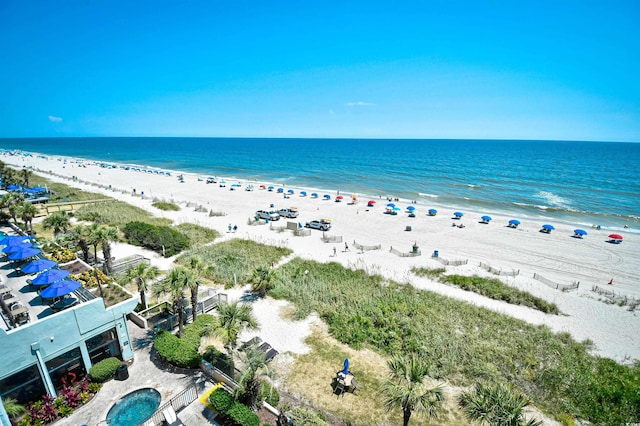 birds eye view of property featuring a water view and a beach view