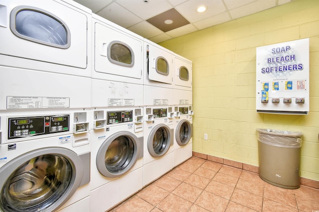 washroom featuring light tile patterned floors, stacked washer and clothes dryer, and washing machine and dryer