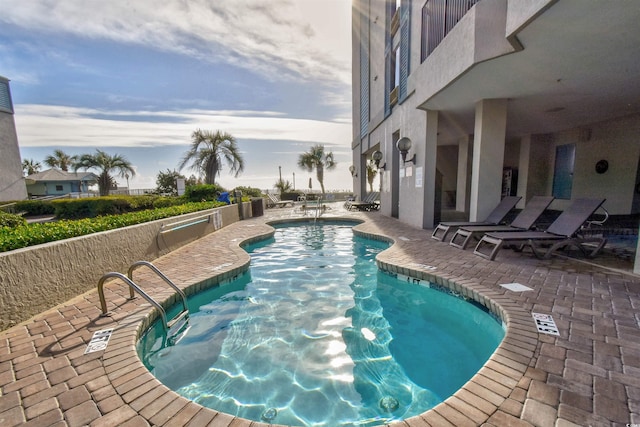 pool at dusk featuring a patio area