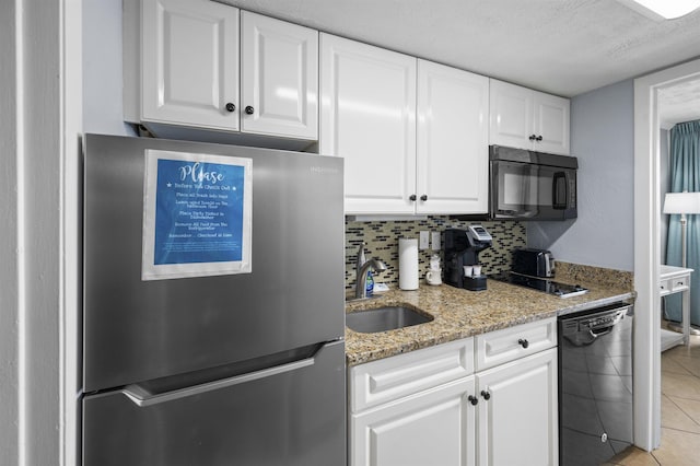 kitchen featuring tasteful backsplash, white cabinets, a sink, and black appliances