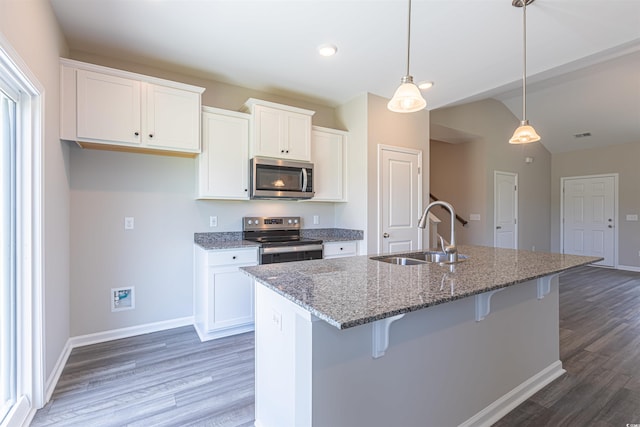 kitchen with dark stone countertops, white cabinetry, sink, and appliances with stainless steel finishes