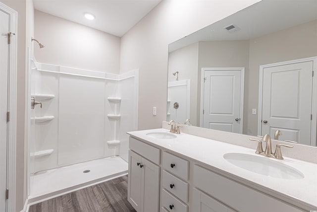 bathroom featuring a shower, hardwood / wood-style floors, and vanity