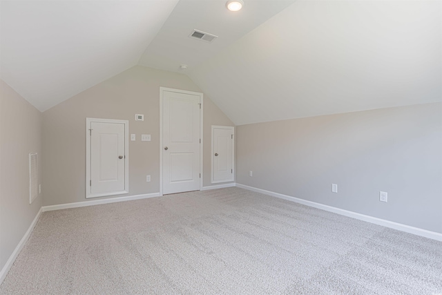 additional living space with carpet flooring and lofted ceiling