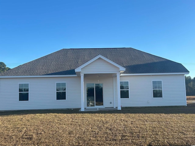 back of property featuring a yard and ceiling fan