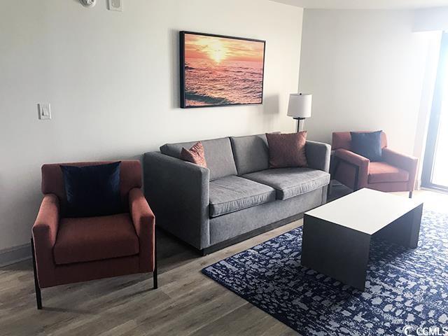 living area with wood finished floors and baseboards