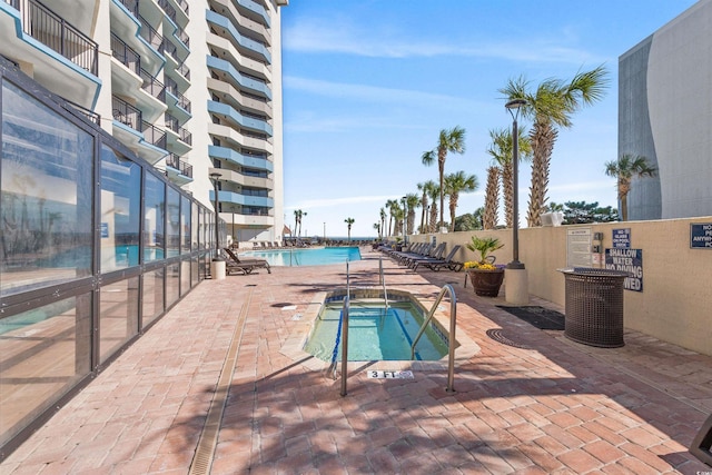 community pool with a community hot tub and a patio area