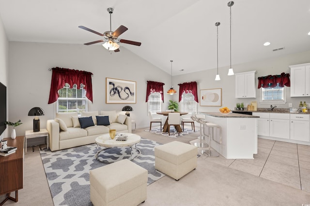 living room with ceiling fan, light carpet, high vaulted ceiling, and sink