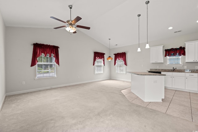 kitchen with white cabinetry, a wealth of natural light, and light carpet