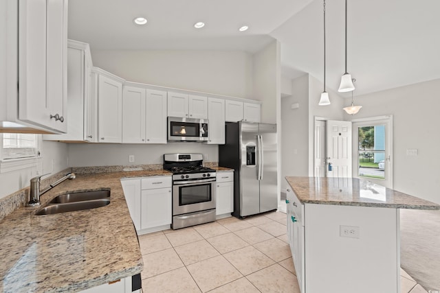 kitchen featuring light tile patterned floors, stainless steel appliances, a kitchen island, and white cabinetry